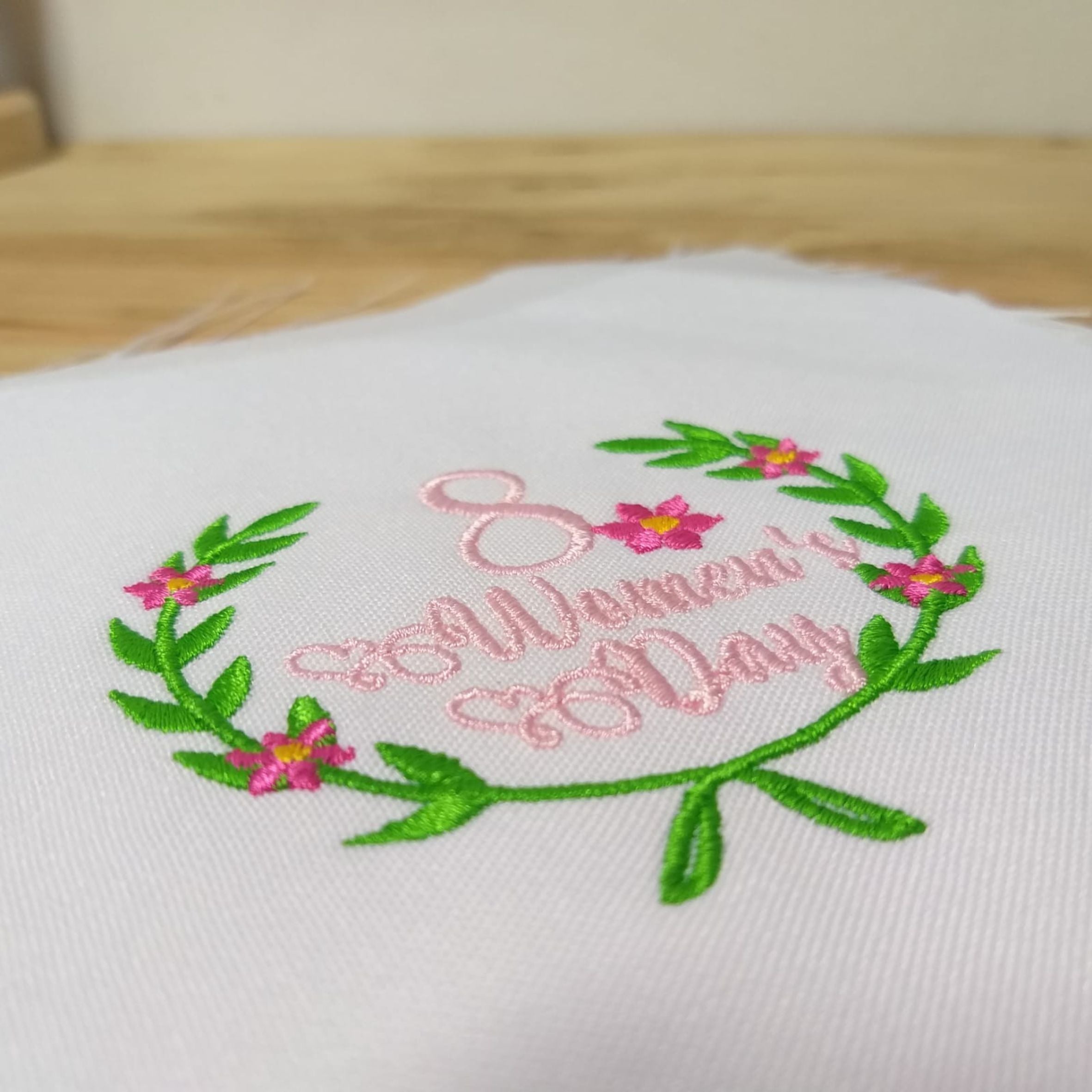 Diseño de bordado a máquina Día de la Mujer con un ocho y flores magenta